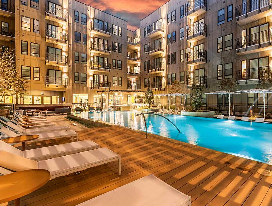Pool courtyard glowing at twilight at The Cooper apartments, Fort Worth TX